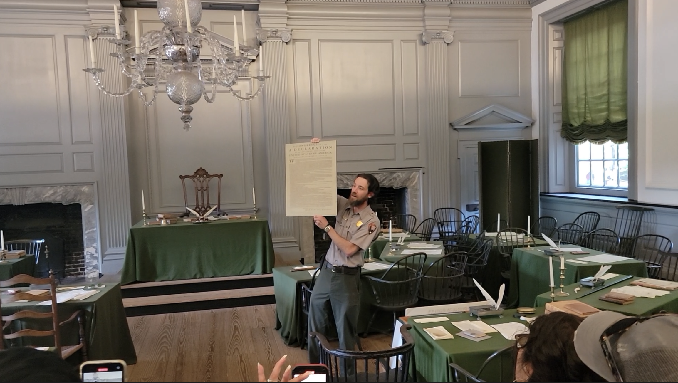 Tour guide in Independence Hall holding a replica copy of the Declaration of Independence
